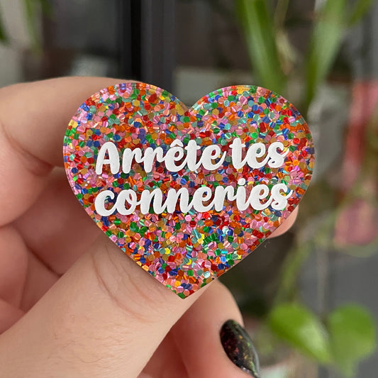 Broche "Arrête tes conneries" en acrylique avec des confettis multicolores