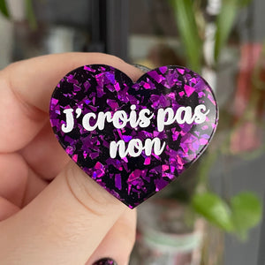 Broche "J'crois pas non" en acrylique noire avec des éclats de confettis violets