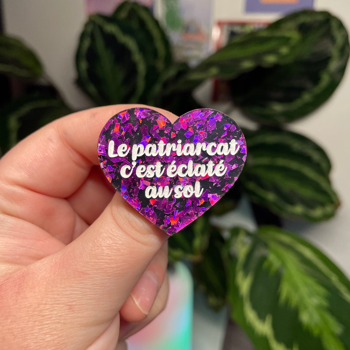 [Contrôle technique] Broche "Le patriarcat c'est éclaté au sol" en acrylique noire avec des éclats de confettis violets