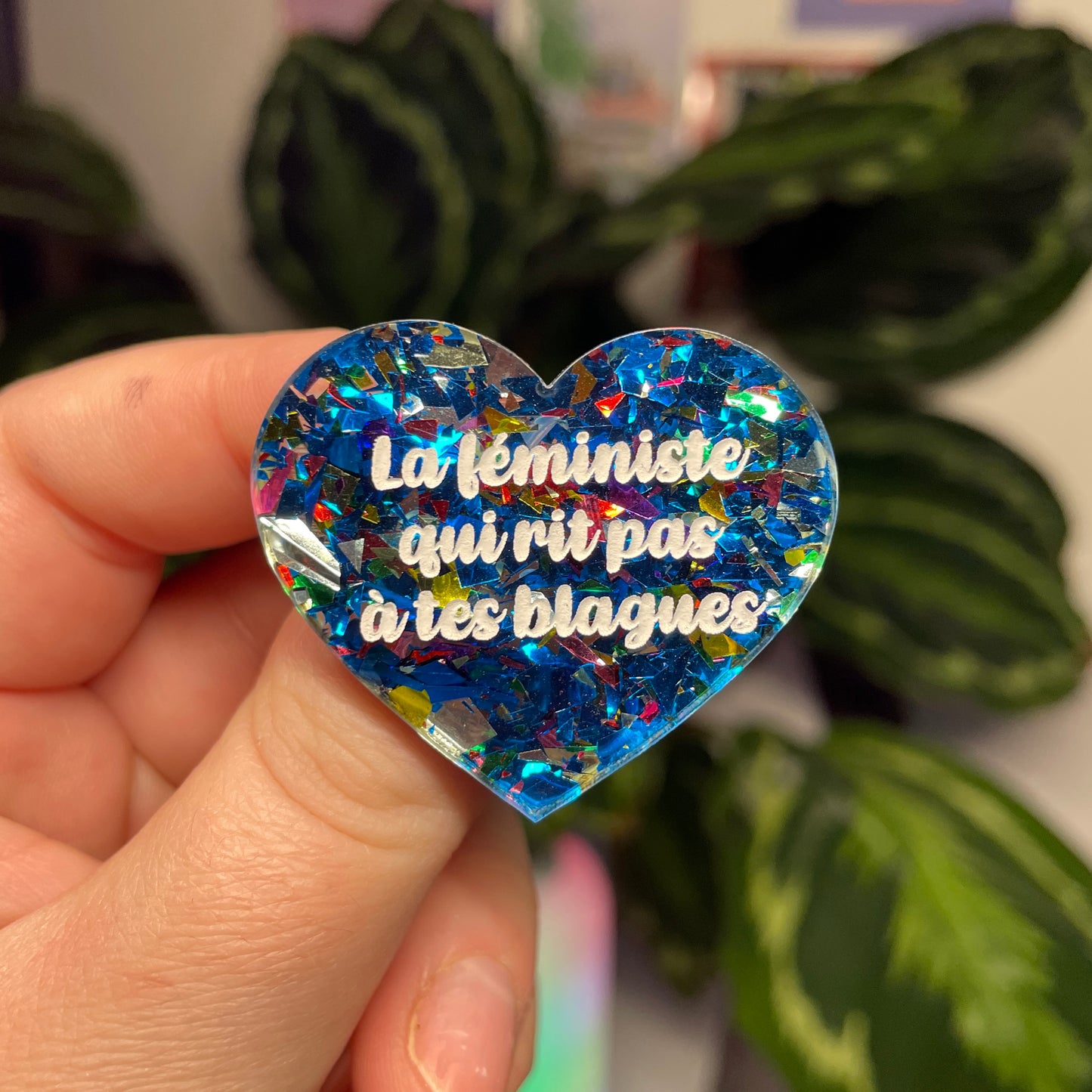 [Contrôle technique] Broche "La féministe qui rit pas à tes blagues" en acrylique transparente avec des éclats de confettis bleus et multicolores