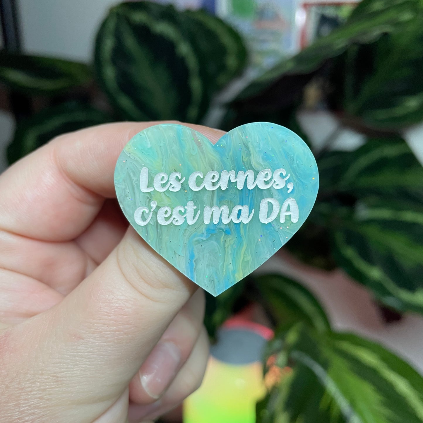 [Contrôle technique] Broche "Les cernes, c'est ma DA" en acrylique marbrée bleue et jaune