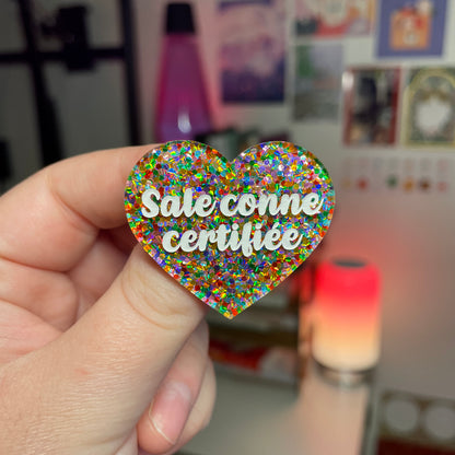 Broche "Sale conne certifiée" en acrylique semi transparente avec des pois multicolores