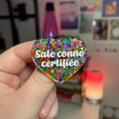 Broche "Sale conne certifiée" en acrylique semi transparente avec des étoiles multicolores
