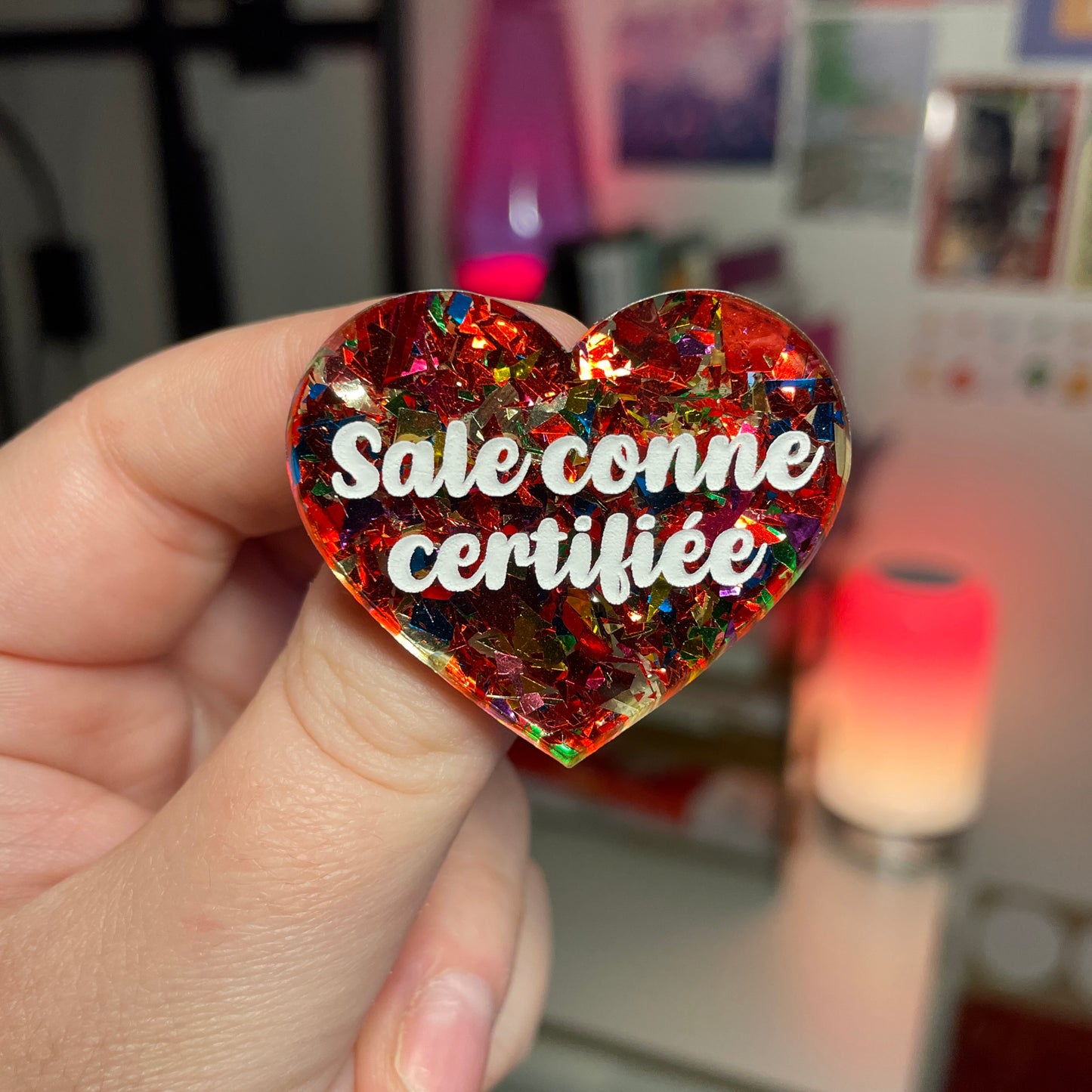 Broche "Sale conne certifiée" en acrylique transparente avec des confettis rouges et multicolores