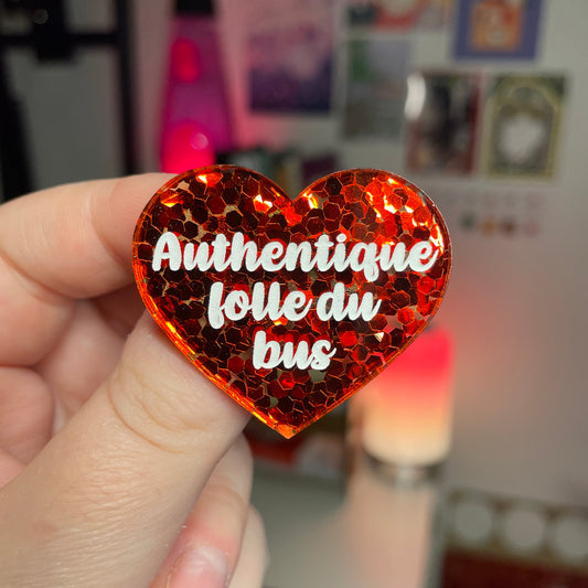 Broche "Authentique folle du bus" en acrylique semi transparente avec des confettis rouges