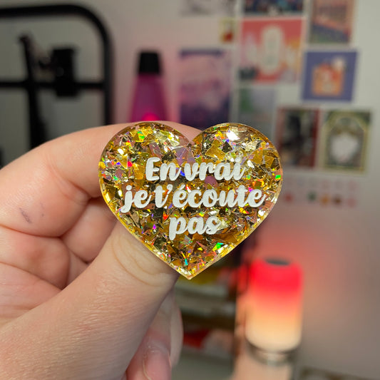 Broche "En vrai je t'écoute pas" en acrylique transparente avec des confettis jaunes