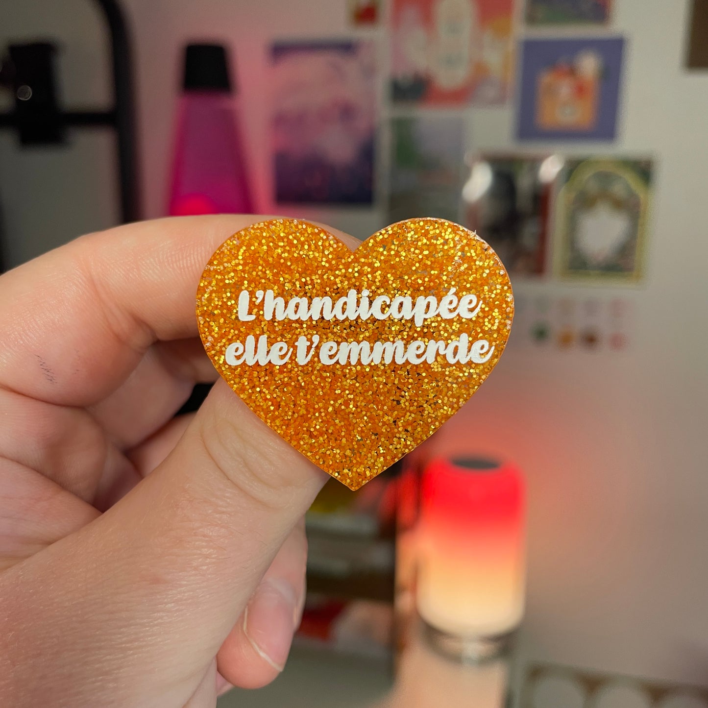 [Contrôle technique] Broche "L'handicapée elle t'emmerde" en acrylique à paillettes oranges