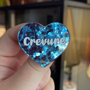 Broche "Crevure" en acrylique semi-transparente avec des confettis bleus