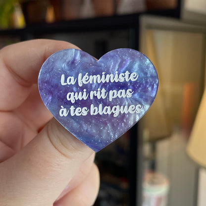 Broche "La féministe qui rit pas à tes blagues" en acrylique marbrée bleue et violette à paillettes