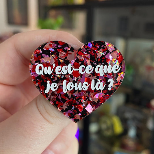 Broche "Qu'est-ce que je fous là ?" en acrylique noire avec des éclats de confettis rouges et roses