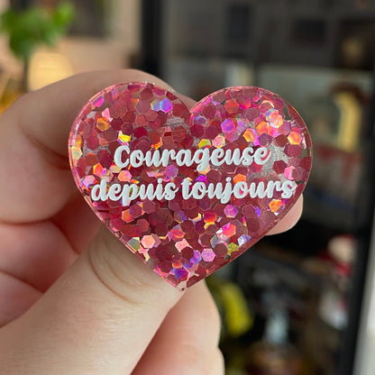 Broche "Courageuse depuis toujours" en acrylique semi-transparente avec des confettis roses