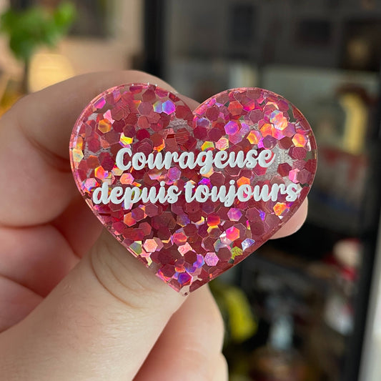 Broche "Courageuse depuis toujours" en acrylique semi-transparente avec des confettis roses