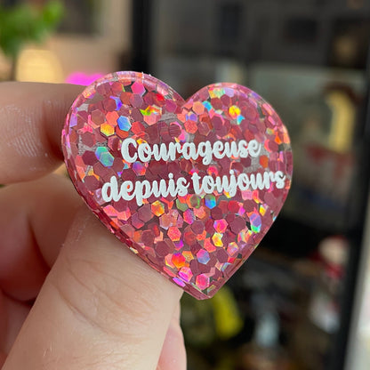 Broche "Courageuse depuis toujours" en acrylique semi-transparente avec des confettis roses