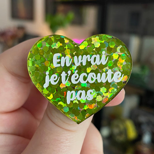 Broche "En vrai je t'écoute pas" en acrylique semi-transparente avec des confettis verts