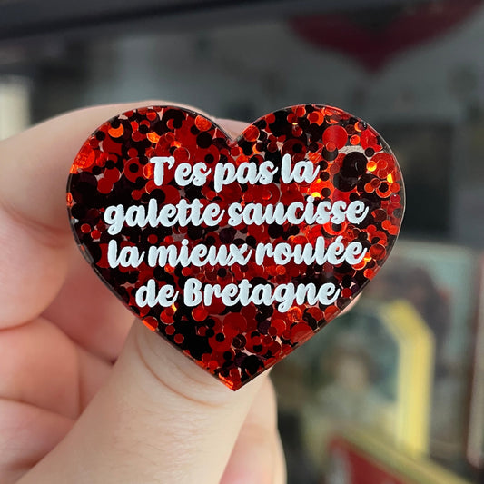 Broche "T'es pas la galette saucisse la mieux roulée de Bretagne" en acrylique semi-transparente à pois rouges et noires