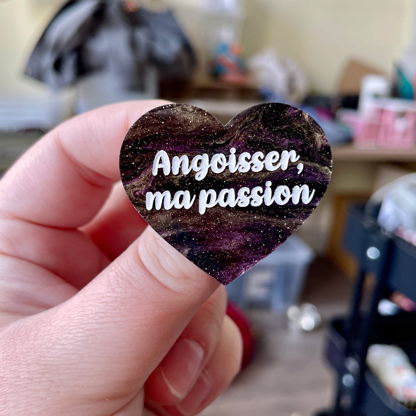 Broche "Angoisser, ma passion" en acrylique marbrée noire, dorée et violette à paillettes