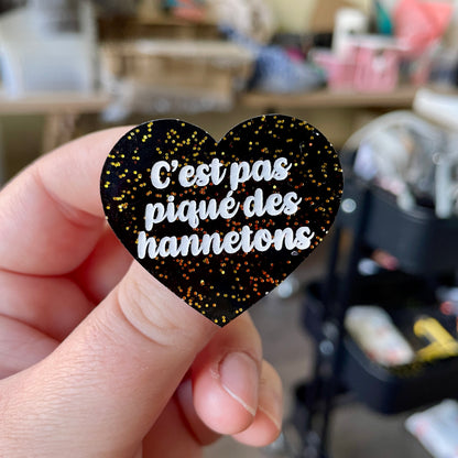 Broche "C'est pas piqué des hannetons" en acrylique noire avec des paillettes dorées