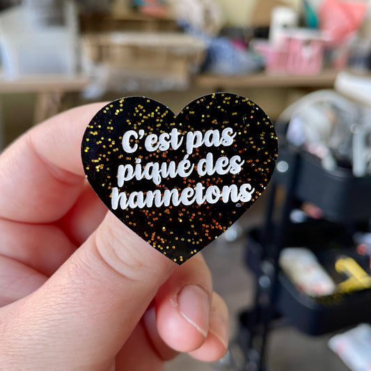 Broche "C'est pas piqué des hannetons" en acrylique noire avec des paillettes dorées