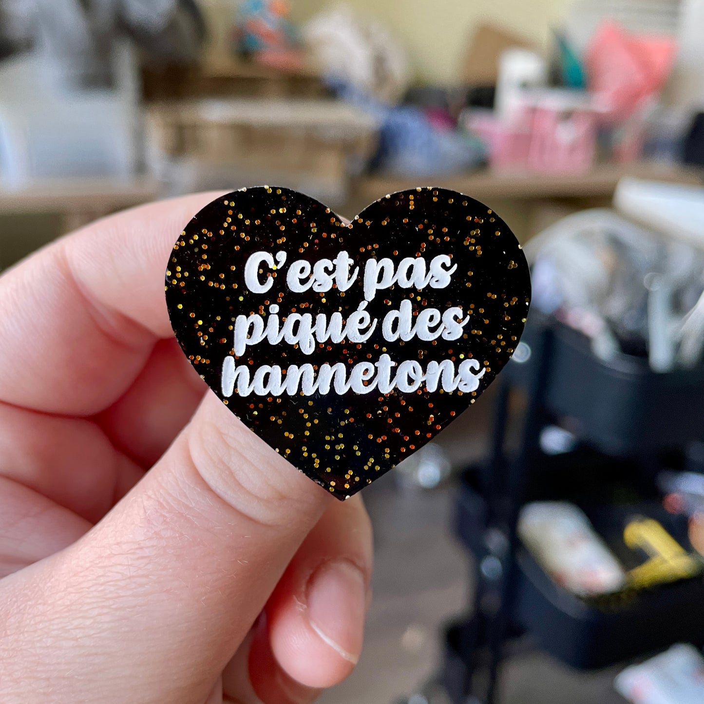 Broche "C'est pas piqué des hannetons" en acrylique noire avec des paillettes dorées
