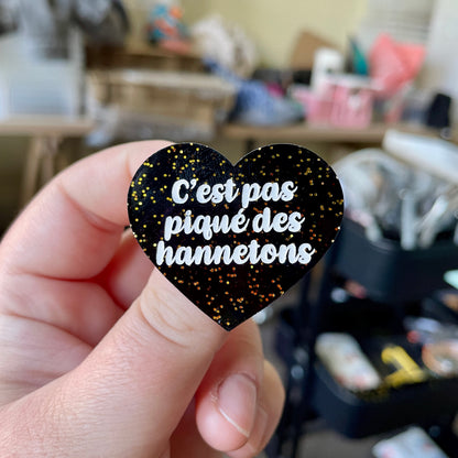 Broche "C'est pas piqué des hannetons" en acrylique noire avec des paillettes dorées