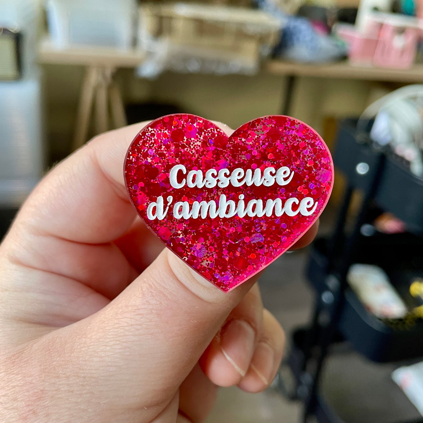 Broche "Casseuse d'ambiance" en acrylique semi-transparente à paillettes rouges