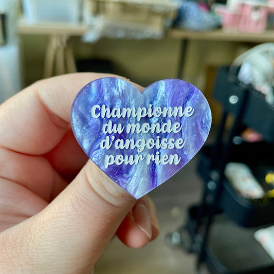 Broche "Championne du monde d'angoisse pour rien" en acrylique marbrée bleue, blanche et violette