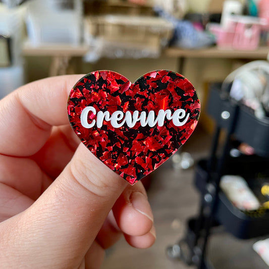 Broche "Crevure" en acrylique noire avec des éclats de confettis rouges