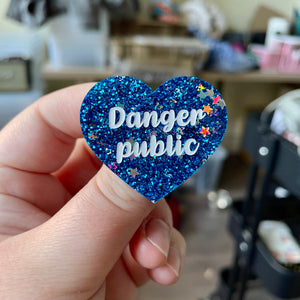 Broche "Danger public" en acrylique à paillettes bleues avec des confettis étoiles