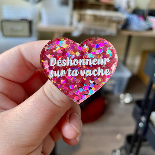 Broche "Déshonneur sur ta vache" en acrylique semi-transparente avec des confettis corail