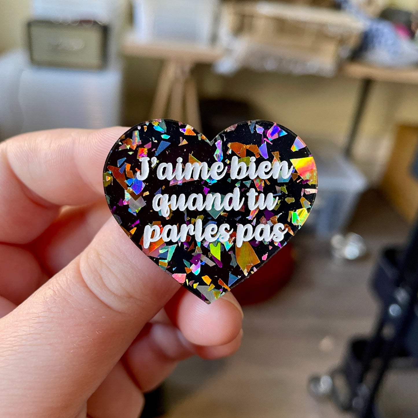 Broche "J'aime bien quand tu parles pas" en acrylique noire avec des éclats de confettis multicolores