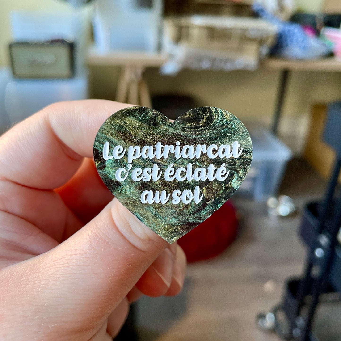 Broche "Le patriarcat c'est éclaté au sol" en acrylique marbrée noire, verte et dorée