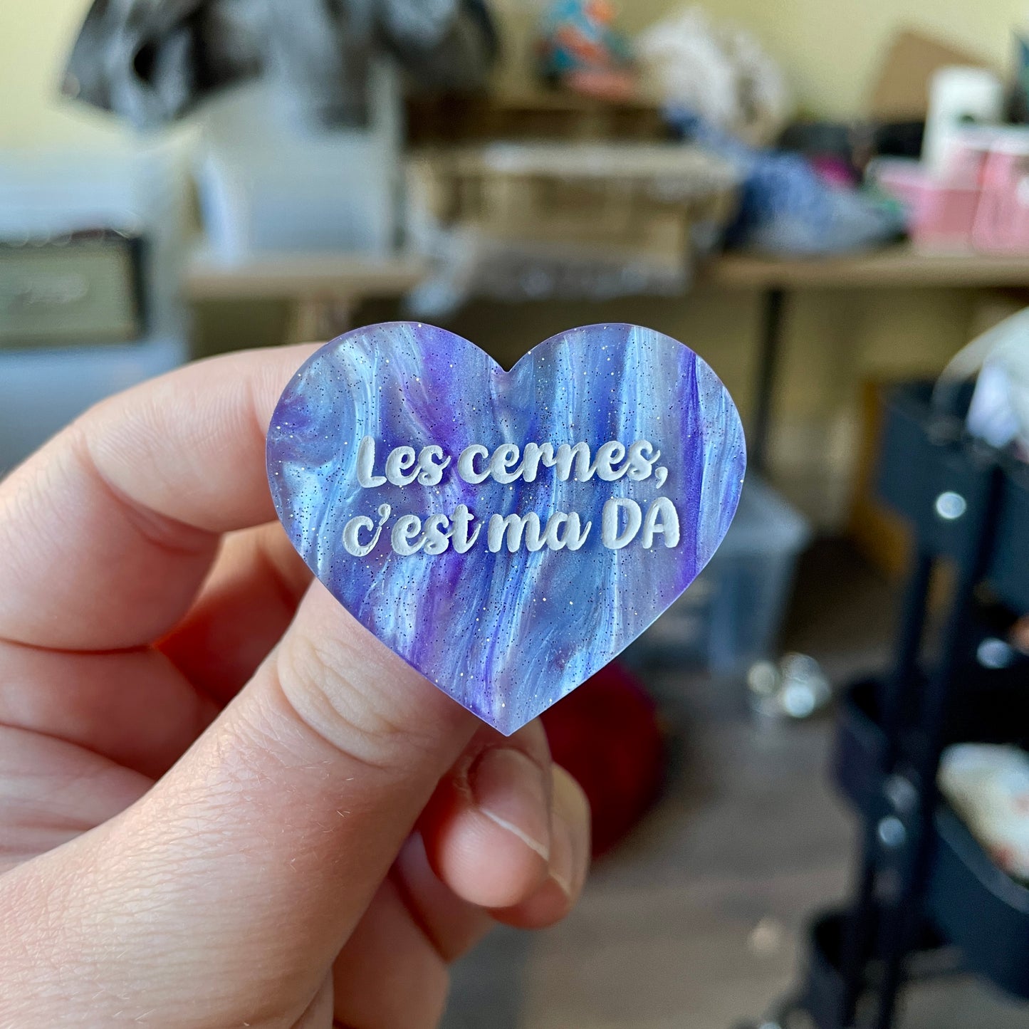 Broche "Les cernes c'est ma DA" en acrylique marbrée bleue, blanche et violette