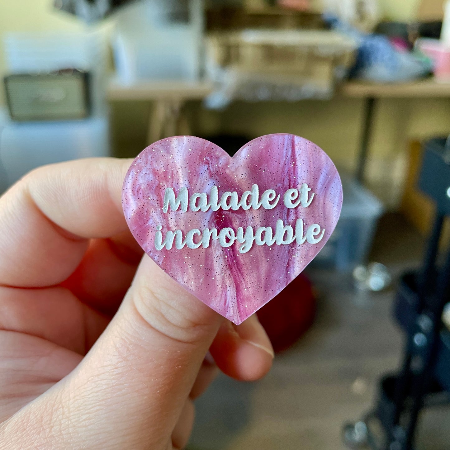 Broche "Malade et incroyable" en acrylique marbrée rose et blanche à paillettes