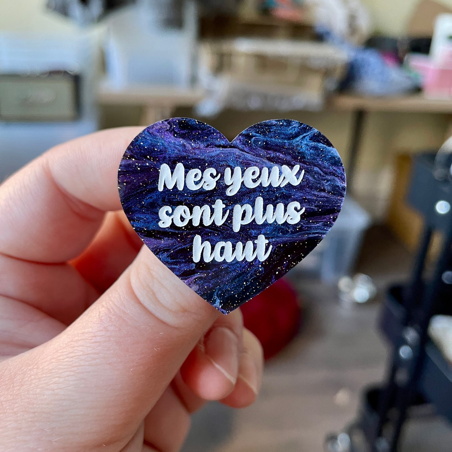 Broche "Mes yeux sont plus haut" en acrylique marbrée noire, bleue et violette à paillettes