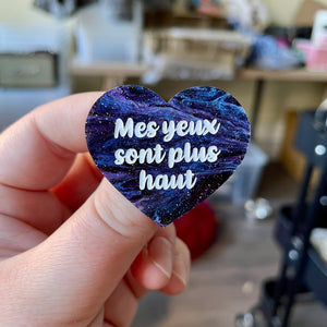 Broche "Mes yeux sont plus haut" en acrylique marbrée noire, bleue et violette à paillettes