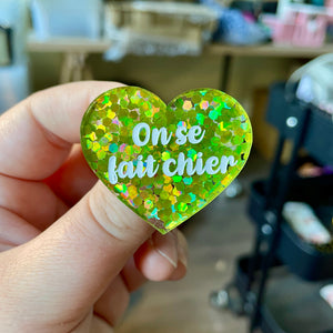 Broche "On se fait chier" en acrylique semi-transparente avec des confettis verts