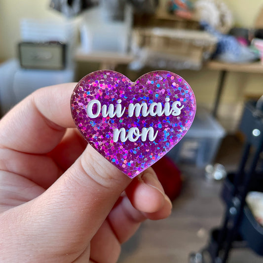 Broche "Oui mais non" en acrylique à paillettes violettes