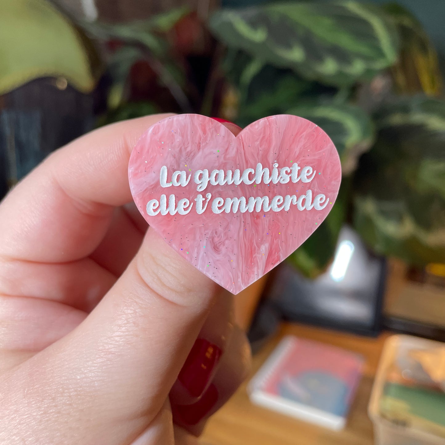 Broche "La gauchiste elle t'emmerde" en acrylique marbrée rouge et rose à paillettes
