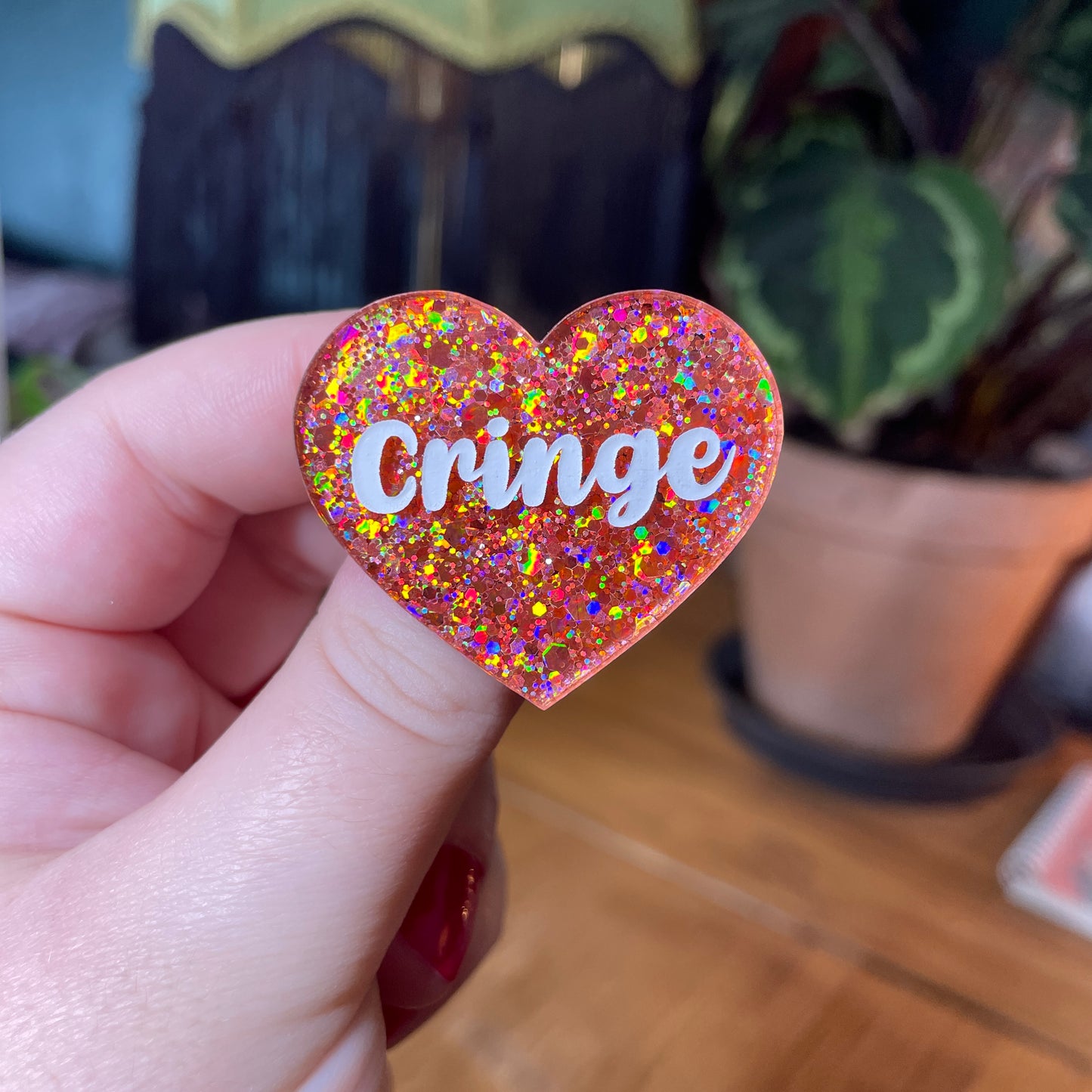 Broche "Cringe" en acrylique semi transparente à paillettes corail