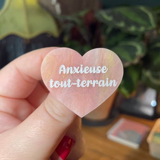 Broche "Anxieuse tout-terrain" en acrylique marbrée jaune, orange et corail à paillettes