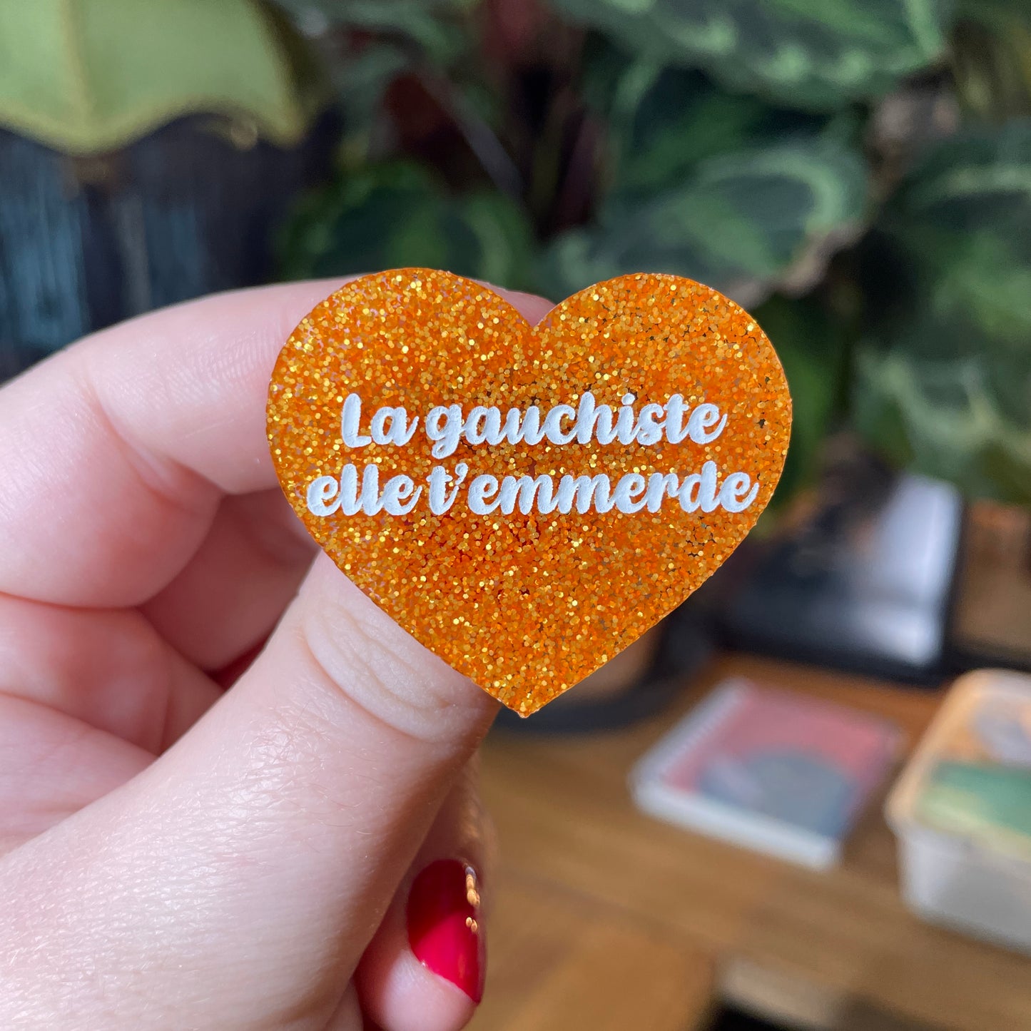 Broche "La gauchiste elle t'emmerde" en acrylique à paillettes oranges