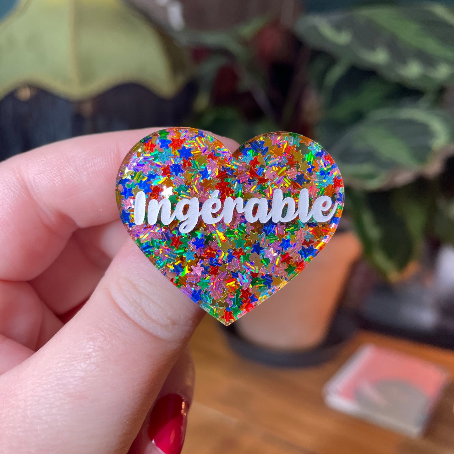 Broche "Ingérable" en acrylique semi transparente avec des étoiles multicolores
