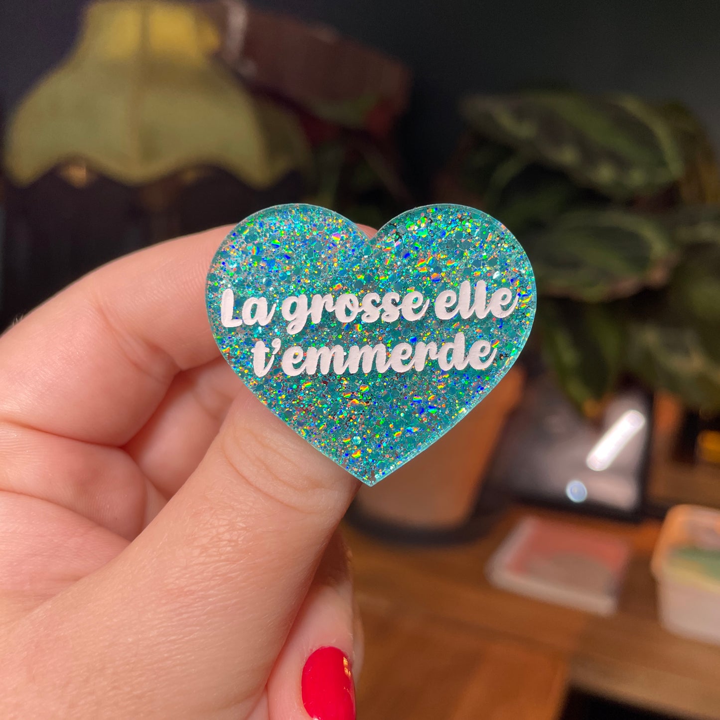Broche "La grosse elle t'emmerde" en acrylique semi transparente avec des paillettes turquoise
