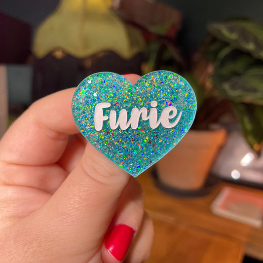 Broche "Furie" en acrylique semi transparente avec des paillettes turquoise
