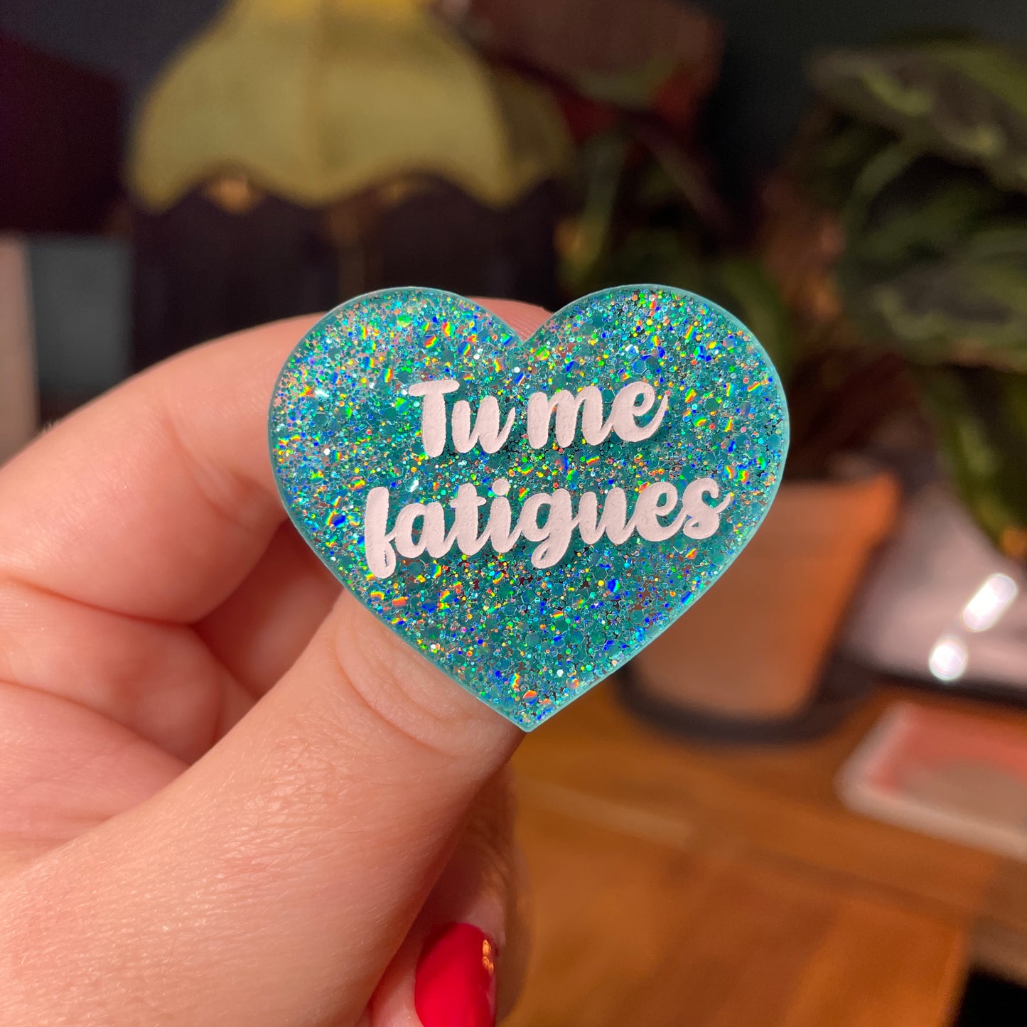 Broche "Tu me fatigues" en acrylique semi transparente avec des paillettes turquoise