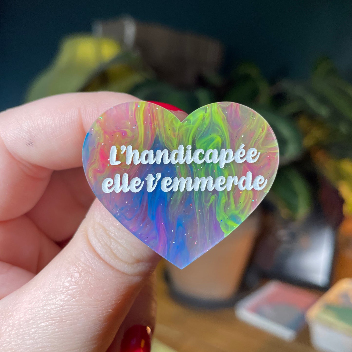Broche "L'handicapée elle t'emmerde" en acrylique semi transparente marbrée multicolore