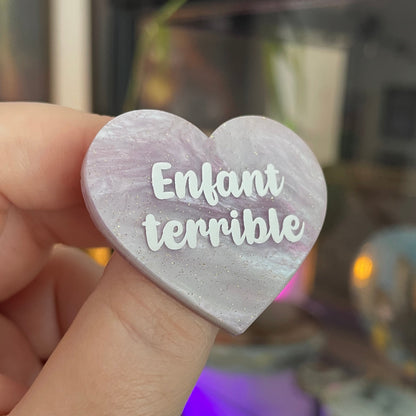 [CONTRÔLE TECHNIQUE] Broche "Enfant terrible" en acrylique violet pâle à paillettes