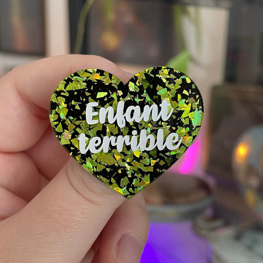 [CONTRÔLE TECHNIQUE] Broche "Enfant terrible" en acrylique noire avec des éclats de confettis jaunes/verts