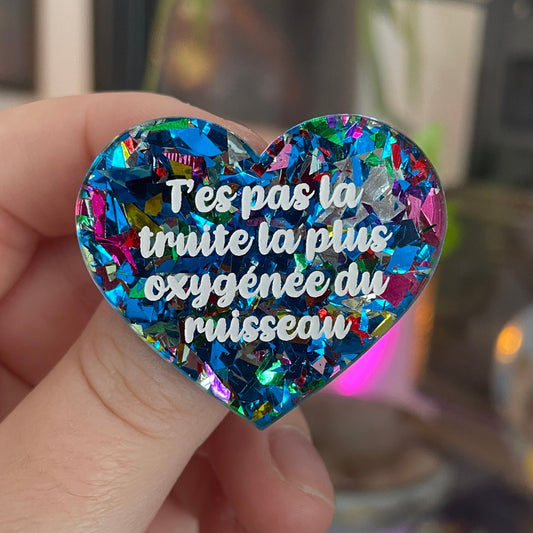 [CONTRÔLE TECHNIQUE] Broche "T'es pas la truite la plus oxygénée du ruisseau" en acrylique avec des éclats de confettis bleus et multicolores