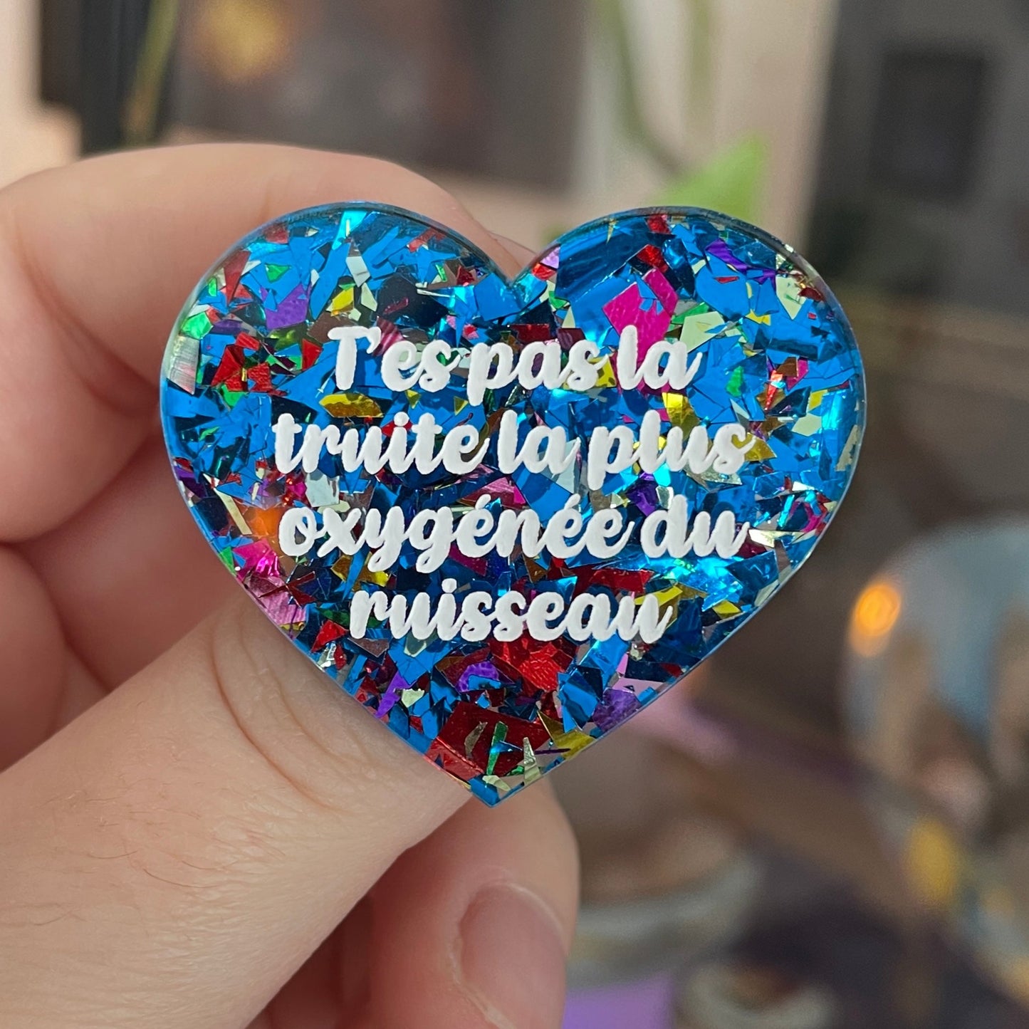 [CONTRÔLE TECHNIQUE] Broche "T'es pas la truite la plus oxygénée du ruisseau" en acrylique avec des éclats de confettis bleus et multicolores
